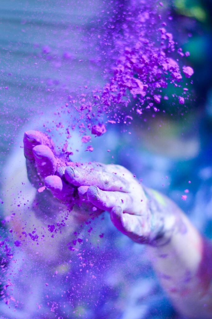 pexels photo 1927595 1927595 1 Close-up of hands throwing vibrant purple powder outdoors, capturing motion and color.